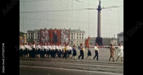 Pioneers march with red communist flags banners. 1960s Petersburg, Russia. People formation walk in parade on city square. Communism old archives. Vintage, archival color film. Retro historic archive photo