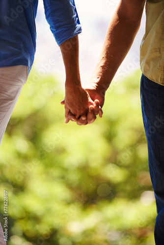 Couple, holding hands and bonding together outdoor for romance and commitment in healthy relationship. People, love and holiday with touch for care, security and walking for date in countryside