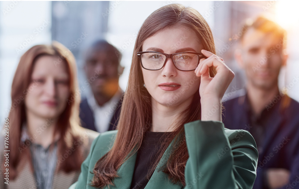 Portrait of a young serious business woman with colleagues