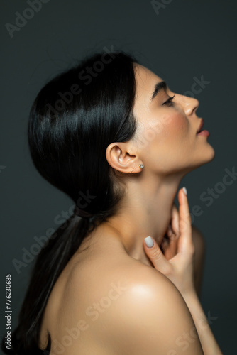 Beautiful woman face closeup portrait hands on skin isolated on dark background