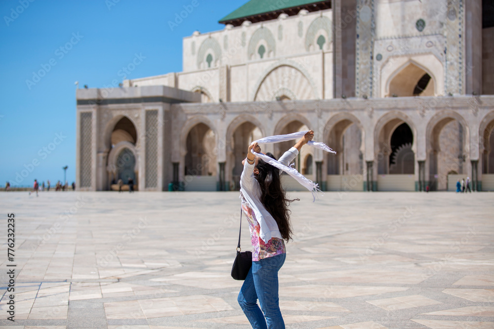 Fototapeta premium Joyful Woman With Scarf at Mosque Courtyard