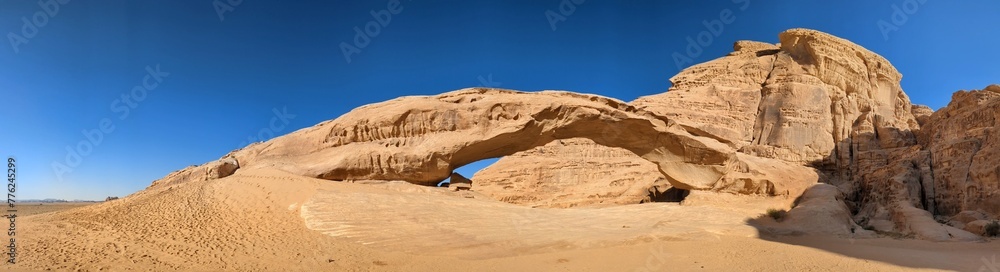 Panorama view of Wadi Rum desert with stone arch formations on flat sand landscape with mountains and rocks .Discover beauty of the earth. National park outdoors landscape.UNESCO World heritage site