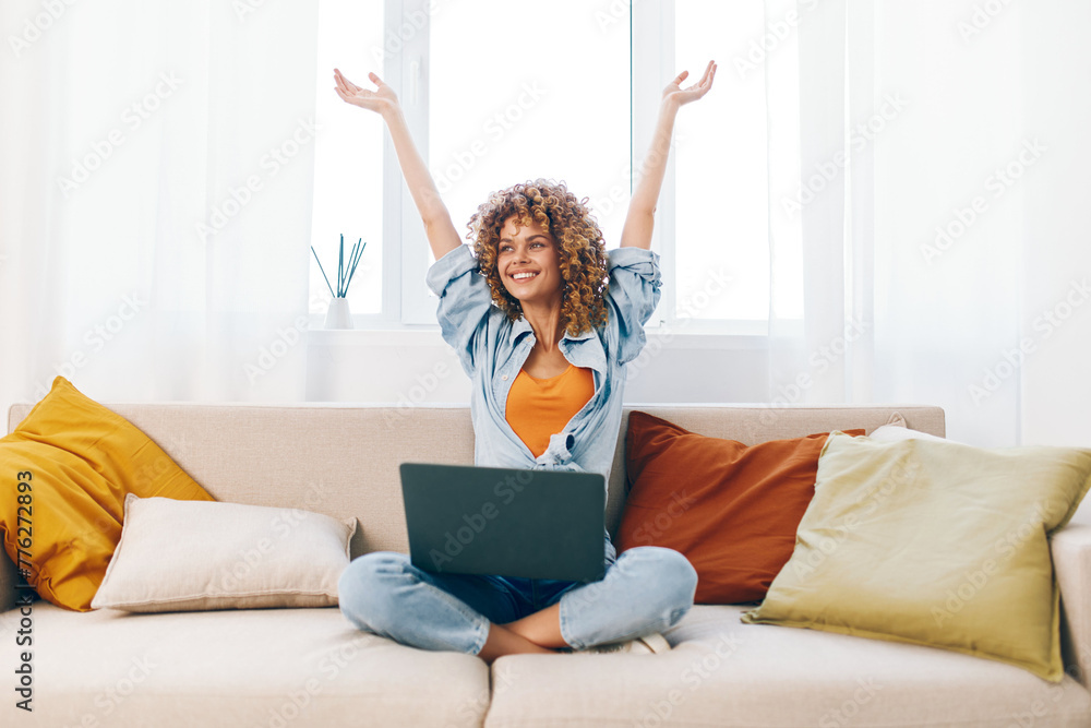 Smiling woman working on laptop in cozy living room Smiling woman working on laptop in cozy living room