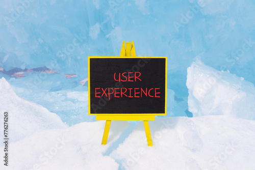 UX user experience symbol. Concept words UX user experience on beautiful yellow black blackboard. Beautiful blue ice background. Business and UX user experience concept. Copy space.
