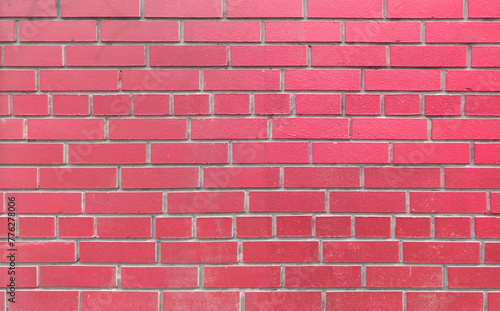 The wall is made of bright red brick, a natural material, stone masonry. Texture for indoor or outdoor background, loft interior.