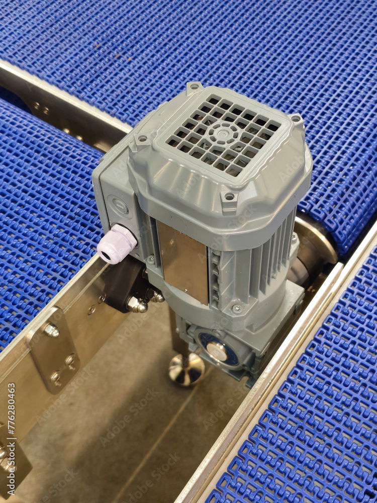 Electric motors in the stainless steel conveyor system with polyurethane, modular belt. Transport systems in industrial factories.