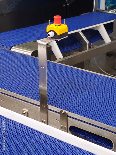 Obraz na płótnie Emergency safety buttons in the stainless steel conveyor system with blue polyurethane, modular belt. Transport systems in industrial factories. w salonie