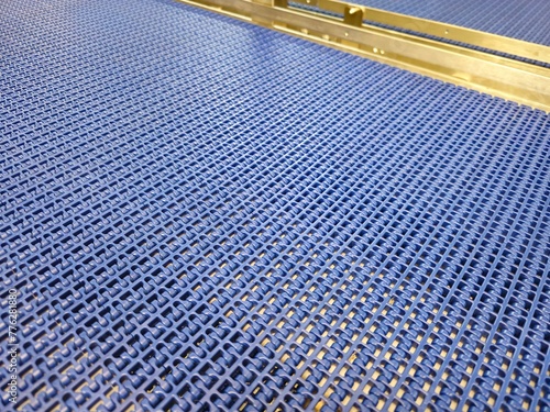 A close-up of a blue polyurethane belt in modular industrial conveyor system. Transport systems in industrial factories.