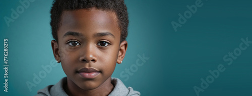 An African American Youthful Boy, Isolated On A Teal Background With Copy Space photo