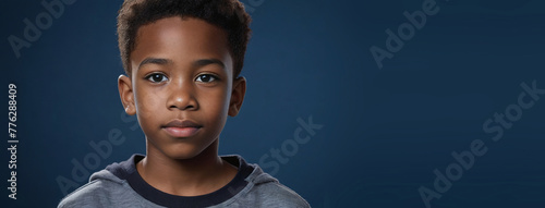 An African American Juvenile Boy, Isolated On A Sapphire Background With Copy Space photo
