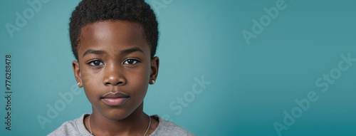 An African American Juvenile Boy, Isolated On A Turquoise Background With Copy Space photo
