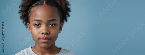 An African American Juvenile Girl, Isolated On A Light Blue Background With Copy Space photo