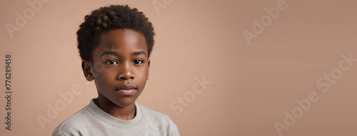 10-12 Years African American Boy, Isolated On A Peach Background With Copy Space photo