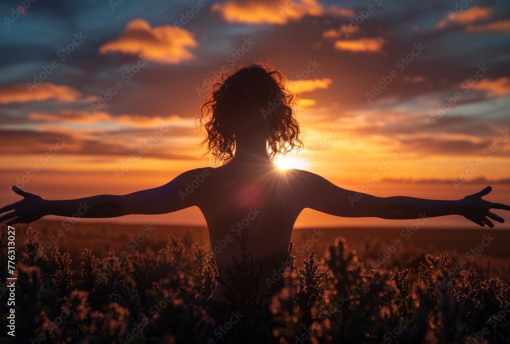 A woman breathing in the sunset with her arms outstretched