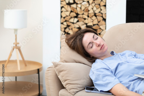 Young tired woman sleeping on the couch after reading book 