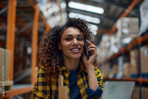 Portrait of an african female employee speaking on the mobile phone in a warehouse