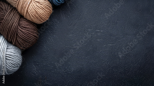 Elegant yarn wool balls in neutral tones on a dark background with knitwear. photo
