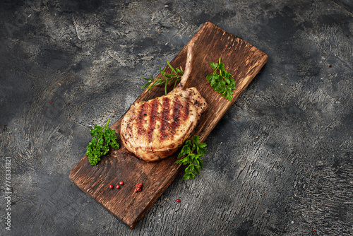 Grilled pork meat with bone and knife on wooden board