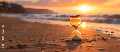 close up hourglass on sandy beach at sunset