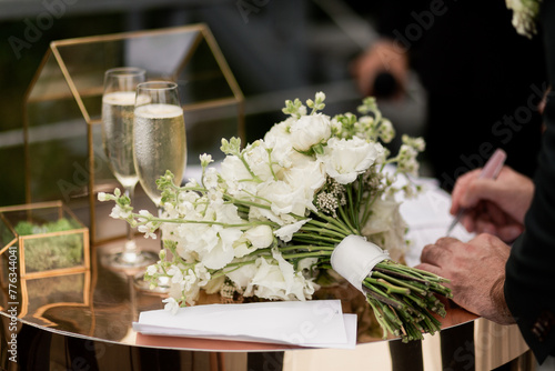 a glass of champagne on the registration table and a wedding bouquet