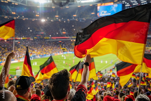 A group of people cheering and raising German flags on a football match