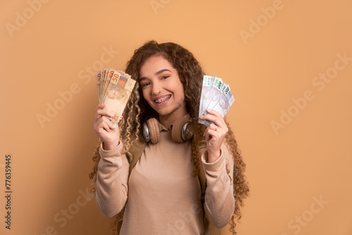 fun brazilian woman with brazil banknotes currency in beige colors. finance, investment, offer, loan concept. 