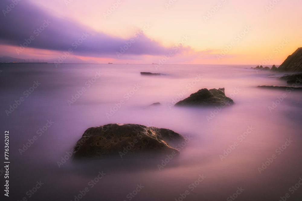 Detail of two rocks emerging from the sea on Azkorri beach in Getxo, Bizkaia, during a sunset