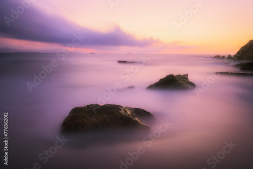 Detail of two rocks emerging from the sea on Azkorri beach in Getxo, Bizkaia, during a sunset