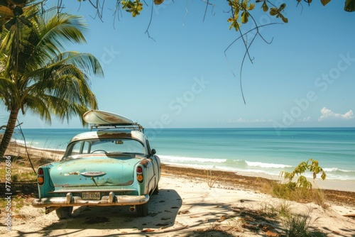 An old car parked on a tropical beach with a surfboard on the roof