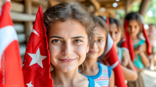 Young girl holding flag in front of group of other young girls. photo