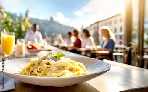 Fettuccine Alfredo, im Hintergrunde in Restaurant mit Gästen 