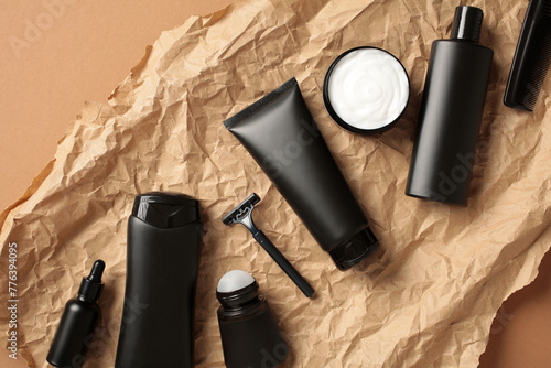 Flat lay men's skin care cosmetics set in black packaging on craft paper. Top view. Natural beauty products design, branding.