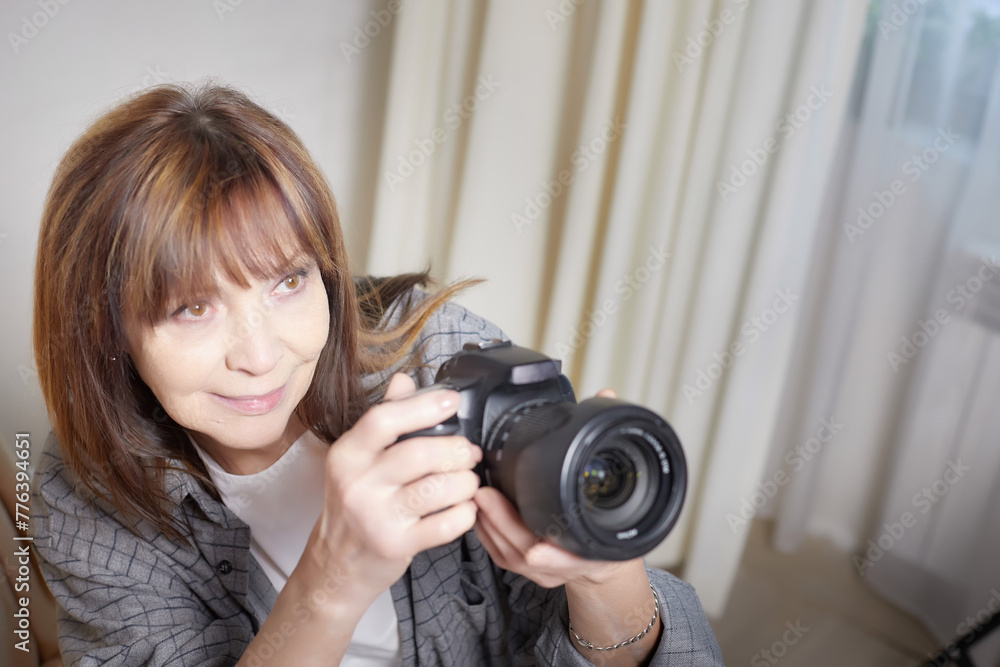 Senior old elderly woman with black camera with a large lens indoors in the studio. A professional photographer. Age Hobby Senior old elderly woman with black camera with a large lens indoors in the studio. A professional photographer. Age Hobby
