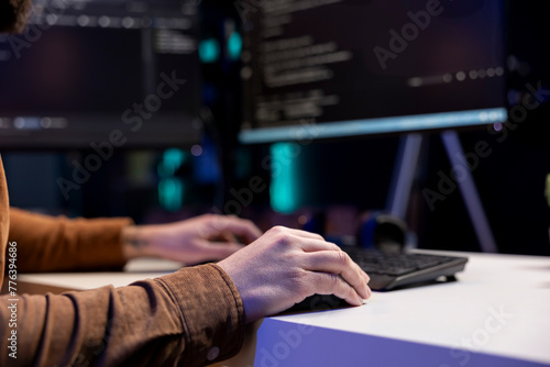 Freelancing cybersecurity admin using computer to look for company security vulnerabilities. IT engineer typing on keyboard, installing fortified code on PC to prevent cyber attacks, close up photo
