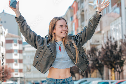 urban blonde girl on the street excited with joy