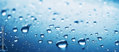 Close-up view of numerous glistening water droplets resting on a smooth blue surface
