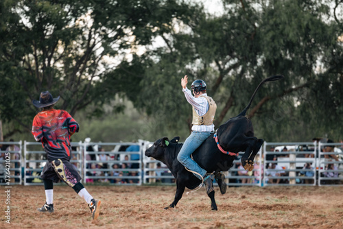 Bull-rider on bucking bull during competitive rodeo event