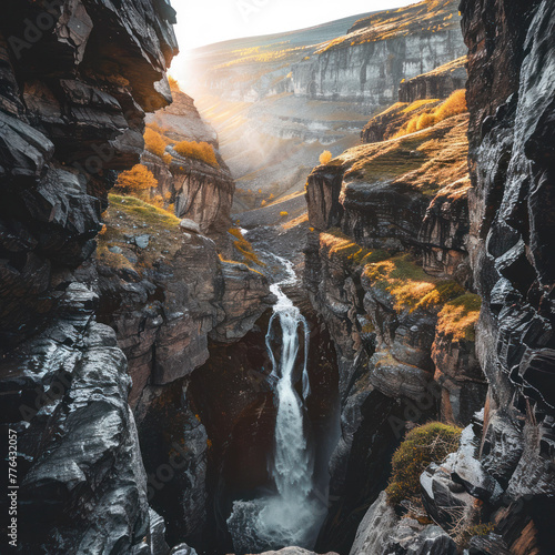 Majestic waterfall cascading down a rugged canyon at sunrise.