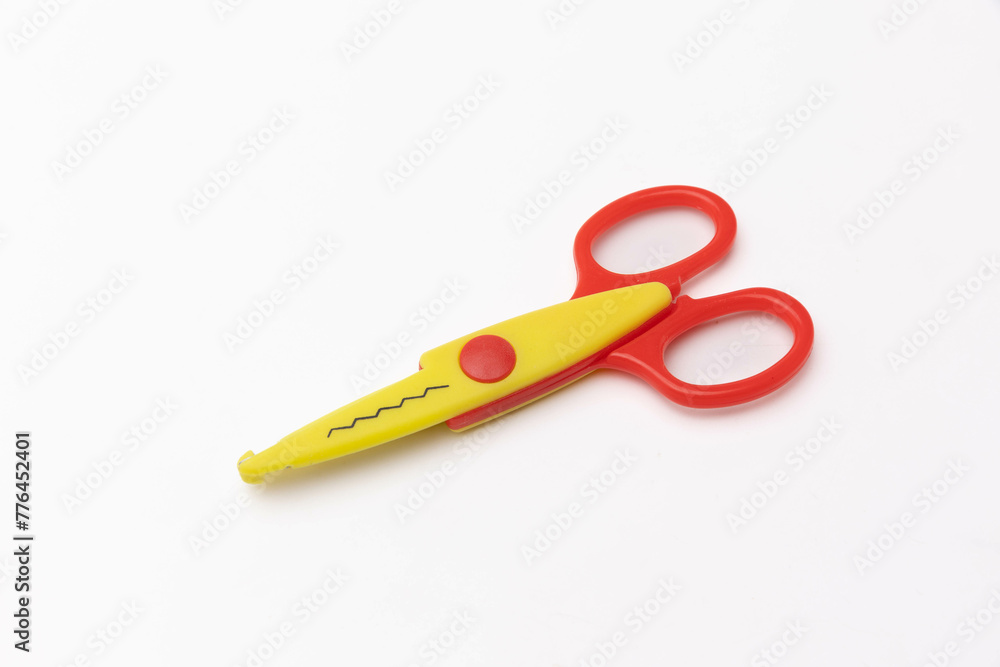 Bright red and yellow plastic scissors isolated on a white backdrop Bright red and yellow plastic scissors isolated on a white backdrop