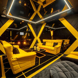 a vip roombin a concert with sofas and chair, With sofas and a yellow sofa chair, luxurious sofas