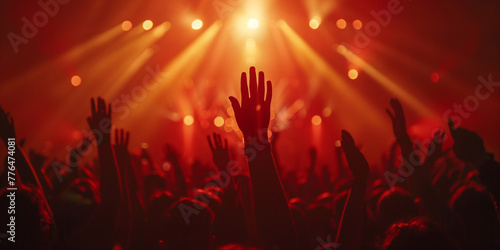 Crowd at a concert with hands raised up in the air. photo