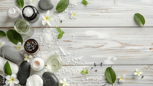 Beauty treatment items for spa procedures are arranged on a white wooden table, including massage stones, essential oils, and sea salt, with ample copy space available. photo