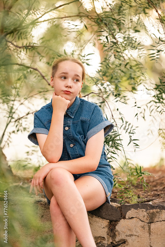 Pre-teen girl sitting under peppercorn tree
