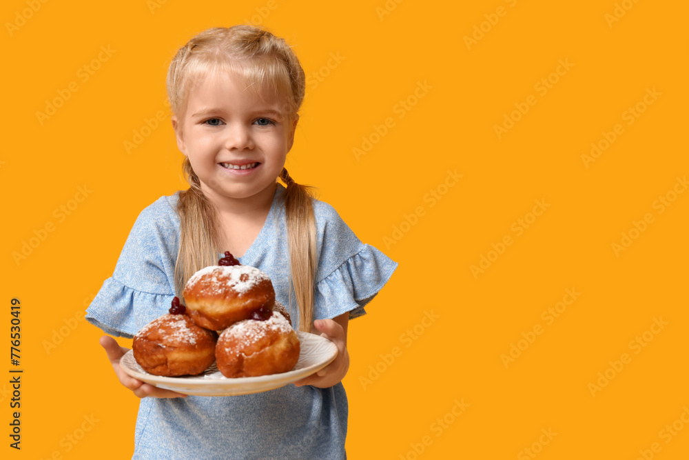 Cute happy little girl holding plate with tasty donuts on yellow background. Hanukkah celebration Cute happy little girl holding plate with tasty donuts on yellow background. Hanukkah celebration