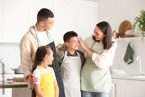 Happy family with aprons in...
