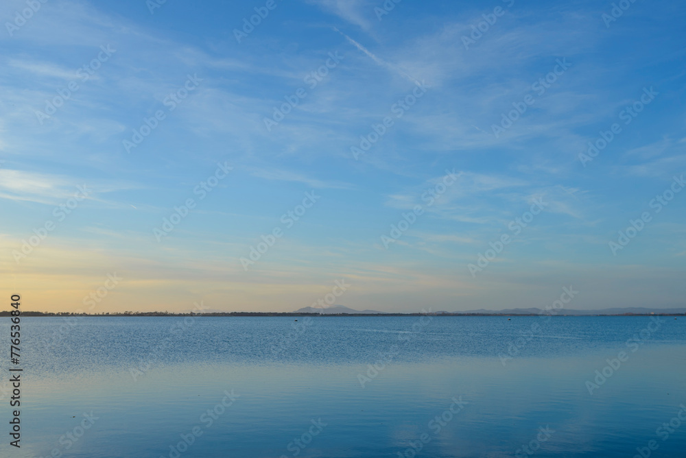 Sky, earth and sea. Panoramic sunset in Orbetello lagoon in Maremma Tuscany, Italy