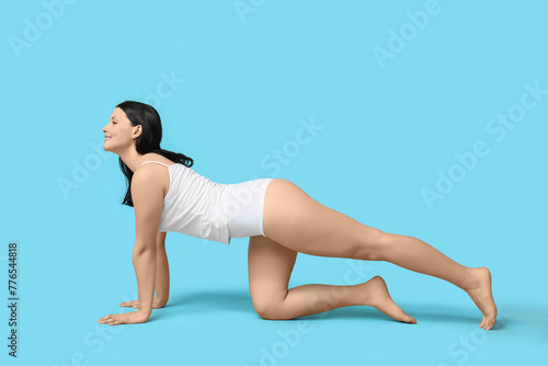 Body positive woman in underwear posing on blue background
