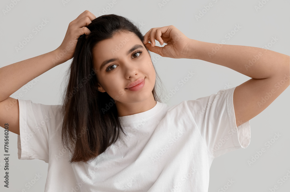 Young woman with dandruff problem examining her hair on white background Young woman with dandruff problem examining her hair on white background