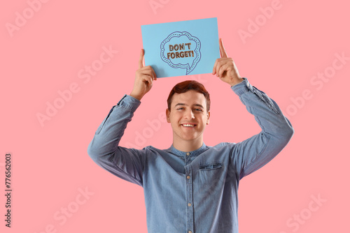 Young man holding paper wit...