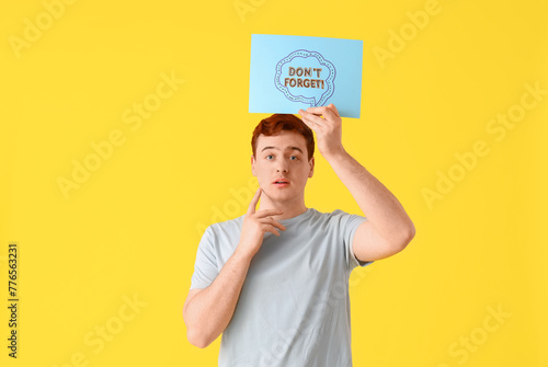 Young man holding paper wit...